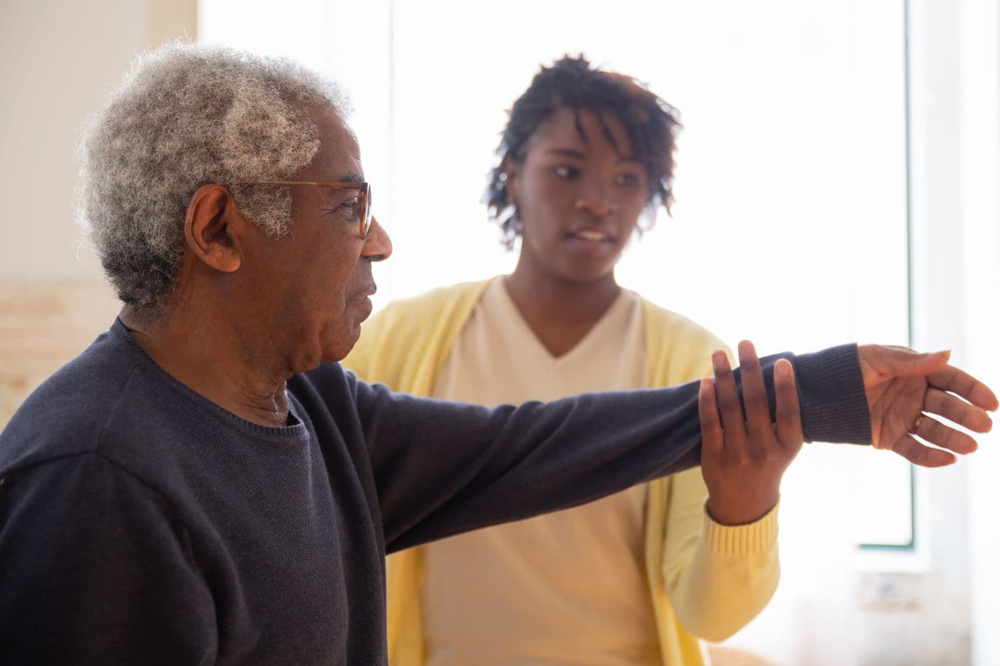 Home healthcare professional guiding a patient through physiotherapy at home